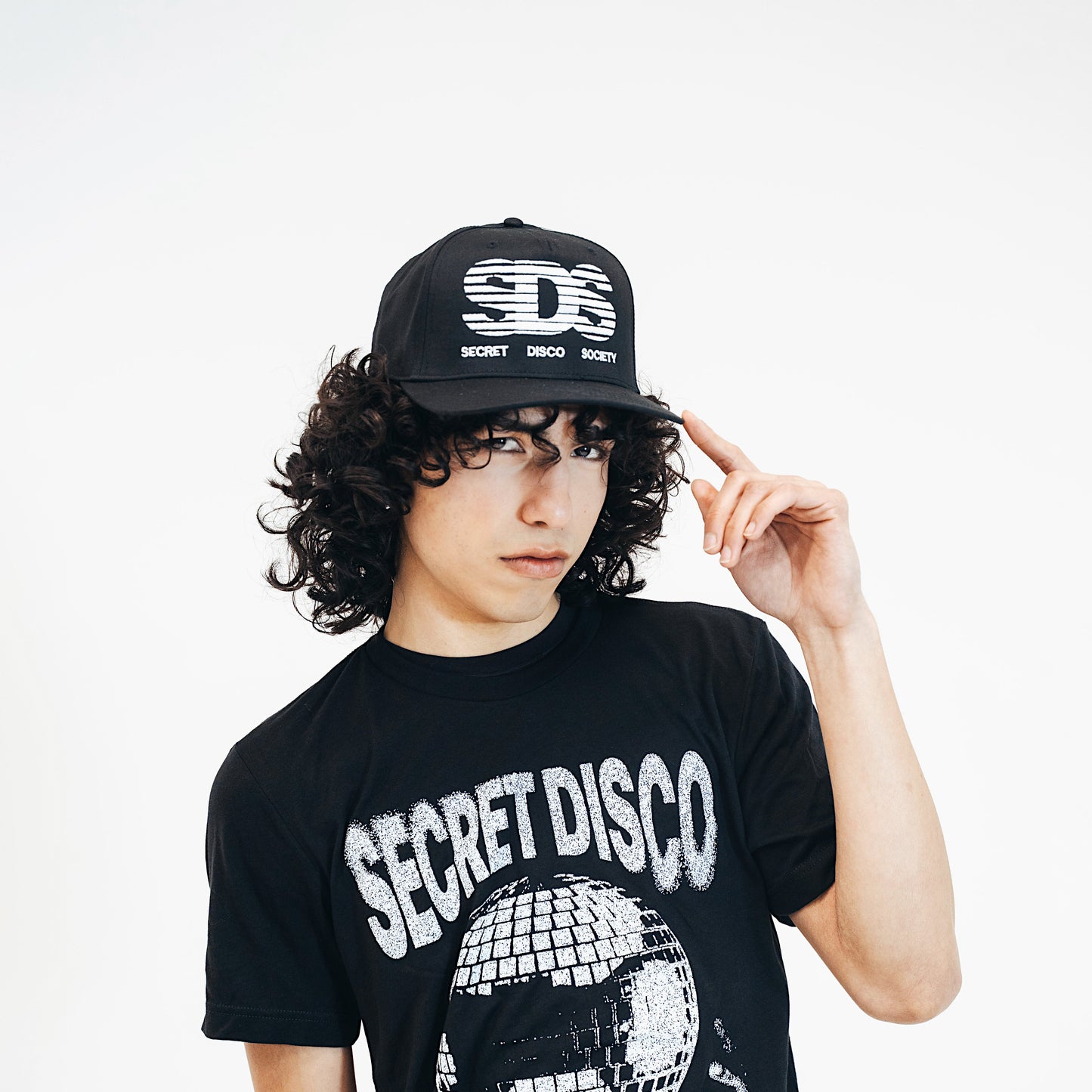 Person wearing a black 'Secret Disco' t-shirt and cap with text on a white background
