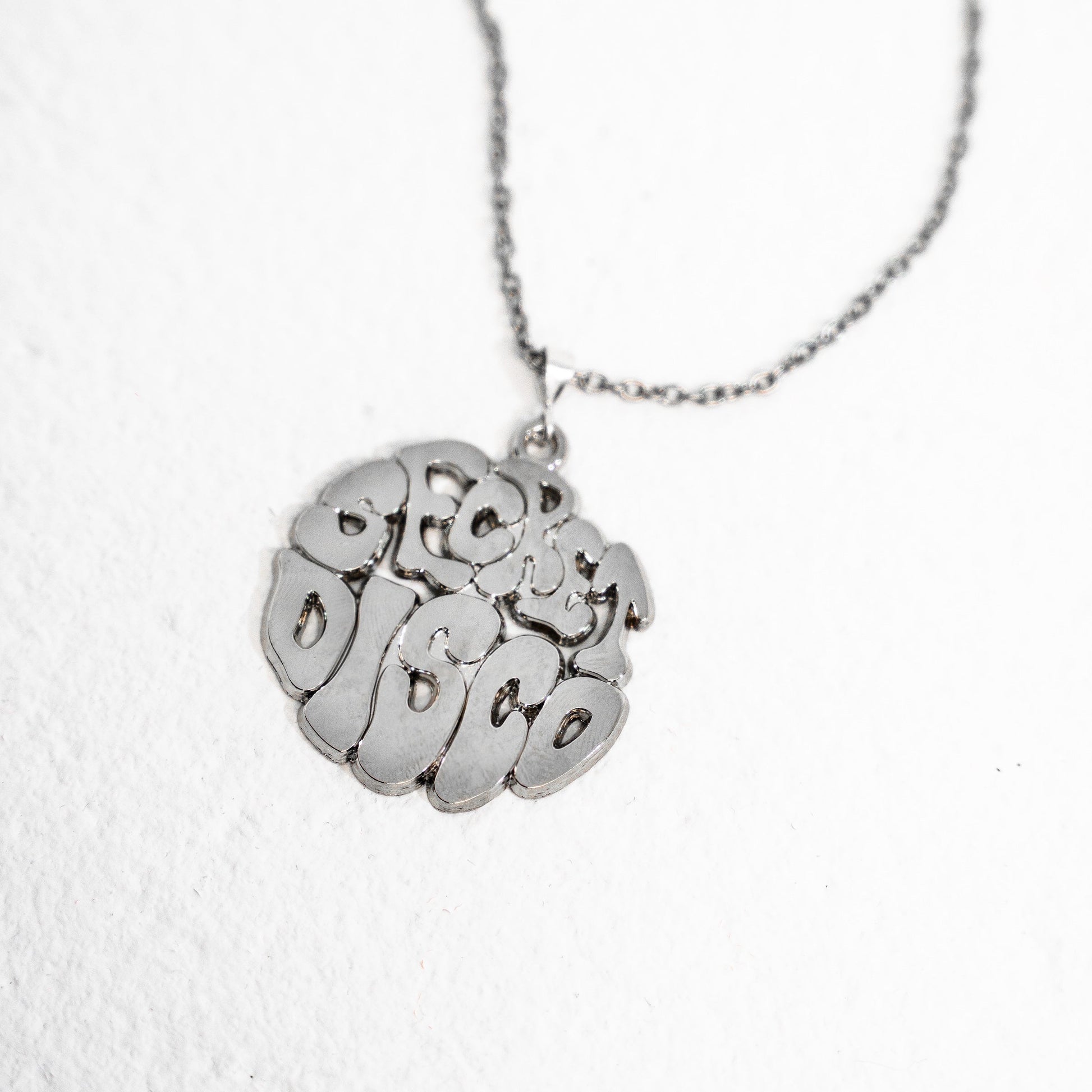 Silver necklace with a secret disco pendant on a white background